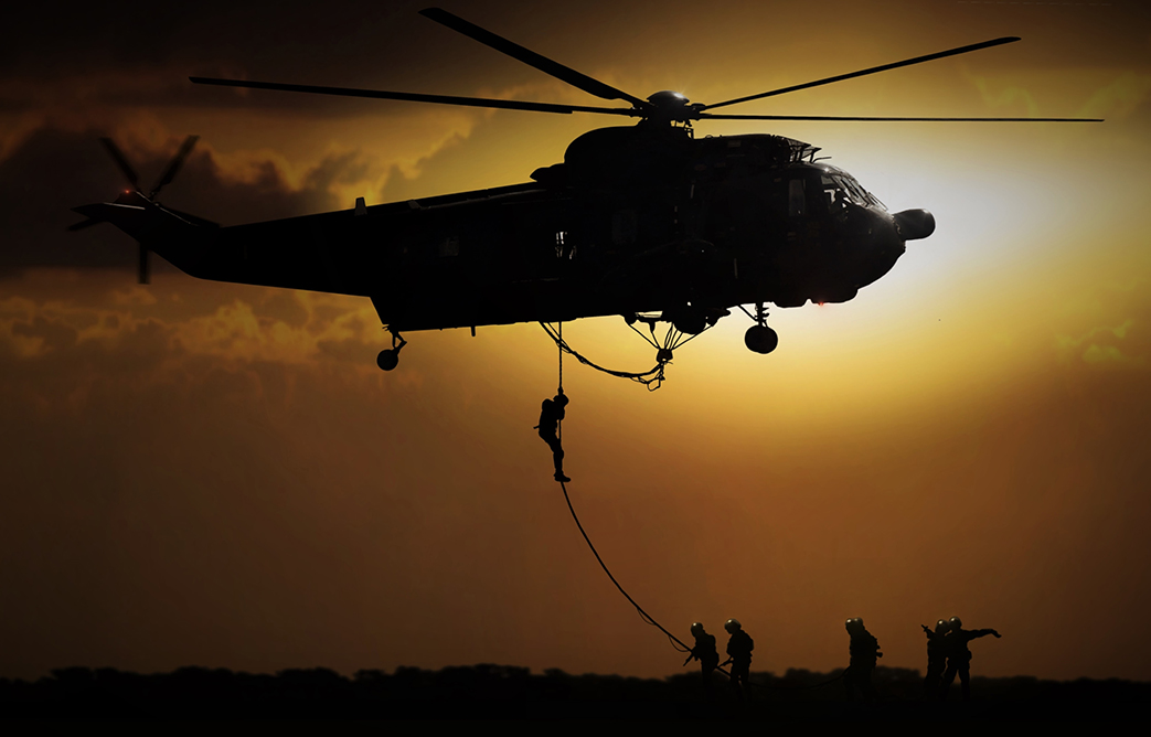 Helicopter dropping soldier during sunset – WOOD Consulting Services, Inc.